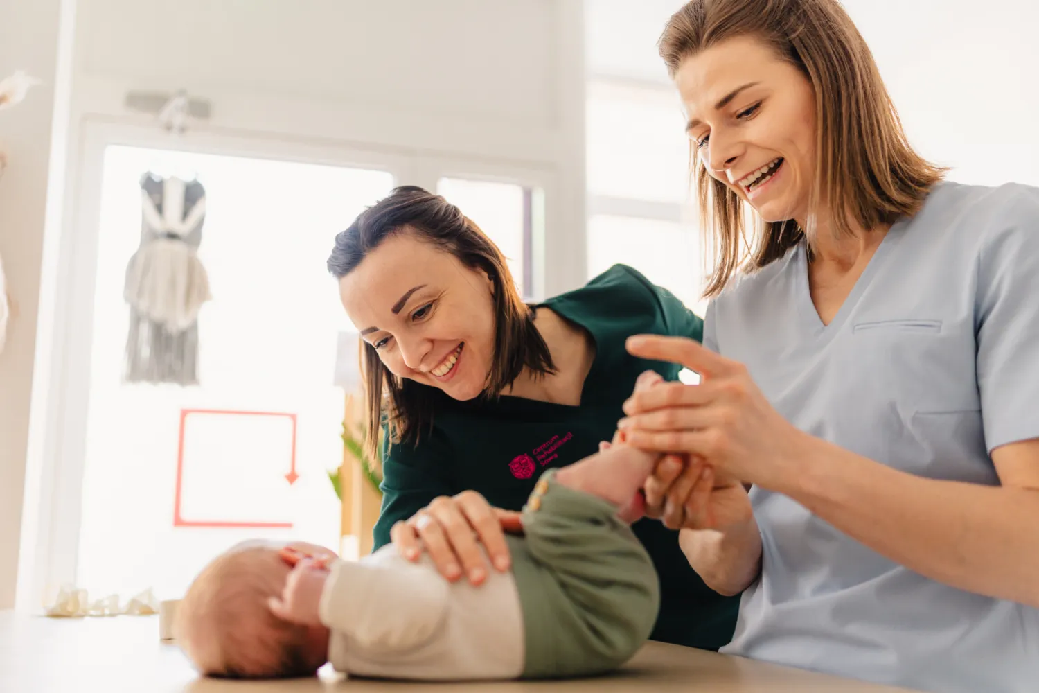 Fizjoterapeutki wykonują ćwiczenia rehabilitacyjne z dzieckiem