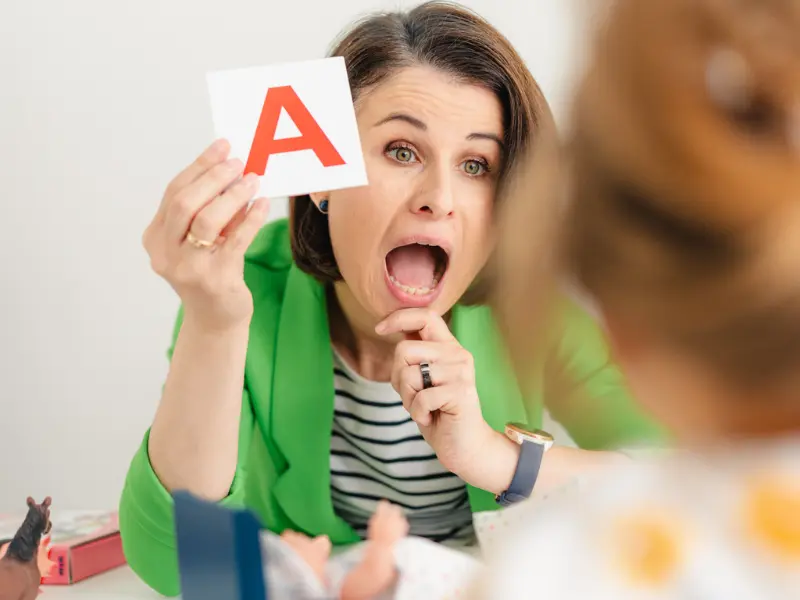 Logopedka pokazuje literę A