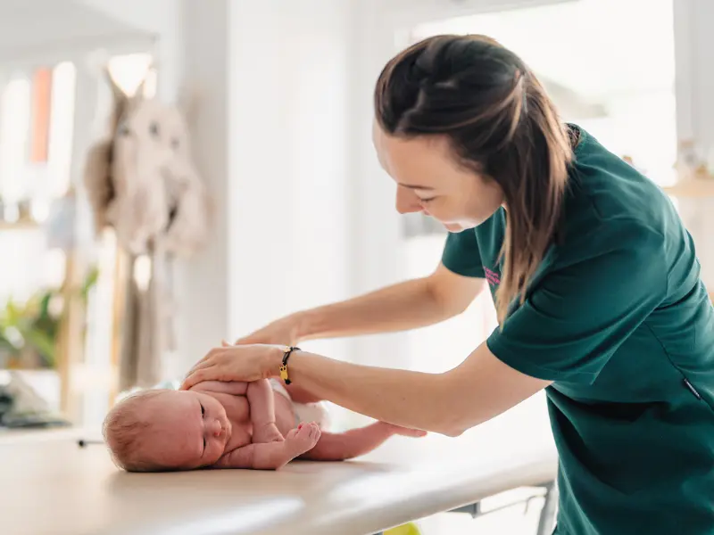 Fizjoterapeutka wykonuje ćwiczenia rehabilitacyjne z dzieckiem